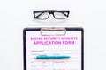 Social security benefits. Application form near pen and glasses on white background top view Royalty Free Stock Photo