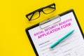 Social security benefits. Application form near pen and glasses on yellow background top view copy space Royalty Free Stock Photo