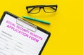 Social security benefits. Application form near pen and glasses on yellow background top view copy space Royalty Free Stock Photo