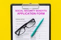 Social security benefits. Application form near pen and glasses on yellow background top view Royalty Free Stock Photo