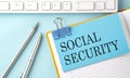 SOCIAL SECURITY text on sticker on the blue background with pen and keyboard Royalty Free Stock Photo