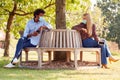 Socially Distanced Couple Wearing Masks Meeting In Outdoor Park During Health Pandemic