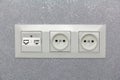 Socket on a light gray silver wall, multifunctional socket with internet access, two European sockets