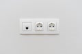 A socket on a light wall, a multifunction outlet with an internet connection, two European-style outlets Royalty Free Stock Photo