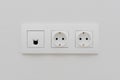 A socket on a light wall, a multifunction outlet with an internet connection, two European-style outlets Royalty Free Stock Photo