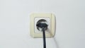 Socket plug with electric plug line on white wall Royalty Free Stock Photo