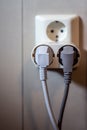 Socket on wall with two pluged electrical outlets and powercords Royalty Free Stock Photo