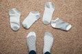 Socks with different patterns scattered on the floor in the house, choice