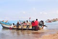 Socotra, Yemen, March 9, 2015 Simple rural fishermen returning from fishing to drag the boat out of the water on the shores of an Royalty Free Stock Photo