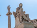 Socrates, the philosopher and Apollo god of the arts marble statues, under clear blue sky.