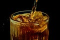 Soda, coke, dark beer pouring from bottle into glass with ice cubes against black background Royalty Free Stock Photo