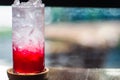 Soda. Red sparkling water with ice in a glass bokeh blur background Royalty Free Stock Photo