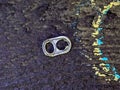 A soda tab on the sidewalk near colorful chalk