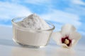 Sodium bicarbonate in a glass jar with a flower on a blue background