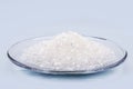 Sodium chloride, known as salt or table salt, important food preservative and popular seasoning, isolated on blue background