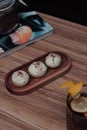 soes cake on a wooden plate with a glass of drink and a magazine