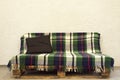 Sofa made of pallets. Plaid and pillow. Interior Royalty Free Stock Photo