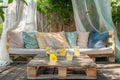 Sofa and table made of pallets. The sofa has soft pillows in yellow, green, and blue. Royalty Free Stock Photo