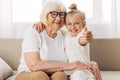Woman grandmother love home granddaughter happy couch hugging girl sofa child family Royalty Free Stock Photo