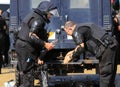 Sofia, Bulgaria on September 2, 2020: Heavily armed police officers wash their eyes from spraying tear gas, with popular non