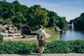 Sofia Park, Ukraine. Man with a backpack in a landscaped park in summer. A tourist with a colored backpack admires the panorama of