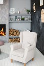 Soft armchair near blackboard wall and fireplace