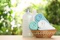 Soft bath towels and laundry detergents on table against blurred background. Royalty Free Stock Photo