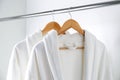 Soft comfortable bathrobes hanging on rack in closet Royalty Free Stock Photo