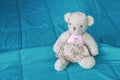 soft bear doll sitting on bed