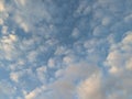 Soft, billowing clouds paint strokes of white against the vast expanse of the cerulean sky