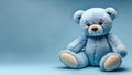 Soft Blue Teddy Bear Sitting on a Matching Blue Background with a Sad Expression Royalty Free Stock Photo