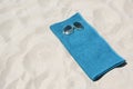 Soft blue towel and sunglasses on sandy beach, space for text Royalty Free Stock Photo