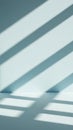 Soft Blue Wall with Diagonal Light and Shadow Stripes Creating a Minimalist and Serene Indoor Space Abstract Background Royalty Free Stock Photo