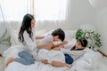Soft blur of Asian mother and her children play together in bedroom and they look happy and fun