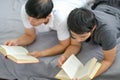 Soft blur of two guys read some books together on bed and they look enjoy with the activity