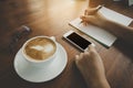 Soft and blurry,teenager hand, writing pencil holder, cell phone touching, Black space for text, Rounded vintage glasses and coffe Royalty Free Stock Photo