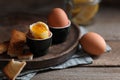 Soft boiled chicken eggs with toasted bread on wooden table Royalty Free Stock Photo