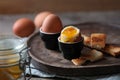 Soft boiled chicken eggs with toasted bread on wooden table Royalty Free Stock Photo