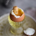 The soft-boiled egg in an eggcup with toasted soldiers for good breakfa