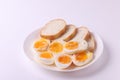 Soft boiled egg halves on the white plate and bread slices Royalty Free Stock Photo