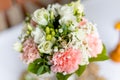 Soft bridal bouquet of fresh flowers and wedding gold rings on celebratory table closeup, blurred background. Elegant Royalty Free Stock Photo