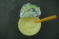 Soft butter with yellow spoon in yellow plastic container cup