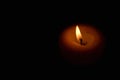 Soft candle light in total darkness with copy space Royalty Free Stock Photo