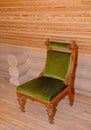 The soft chair with a velvet upholstery stands near a timbered w