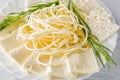 Soft cheese Chechil and Guda on plate with herbs on wooden table. Close up image Royalty Free Stock Photo