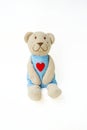 Soft children`s toy in the form of a bear with a heart on a white background. Royalty Free Stock Photo