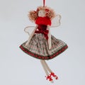 Soft Christmas toy in the shape of an elegant ballerina in a red dress with a checkered skirt Royalty Free Stock Photo