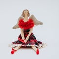 Soft Christmas toy in the shape of an elegant ballerina in a red dress with a checkered skirt Royalty Free Stock Photo