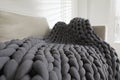 Soft chunky knit blanket on sofa in room, closeup Royalty Free Stock Photo