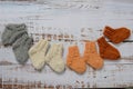 Soft and chunky, warm baby socks, hand-knitted, on white wooden background